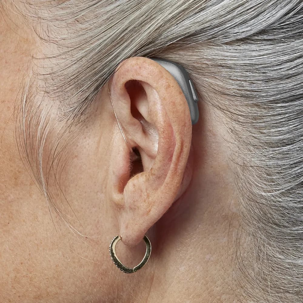 A Bernafon Encanta behind-the-ear hearing device worn in place