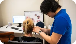 Audiologist performing ear exam